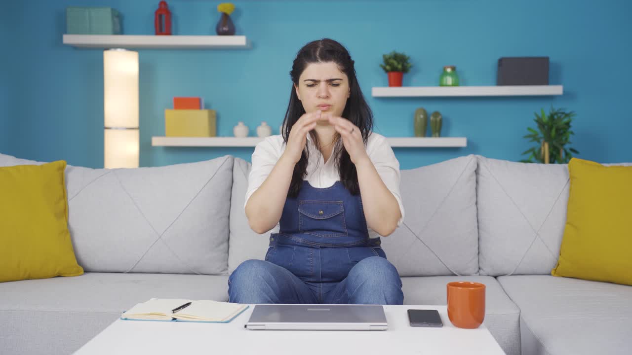 mujer cerrando la computadora portátil con expresión de enojo.