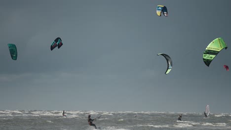 Kite-surfers-riding-the-waves-on-Sonderstrand,-Romo-island,-Denmark