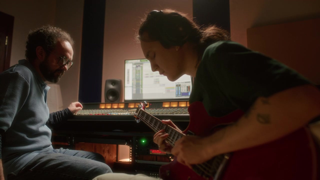 Guitarist and Sound Producer Recording Music in Professional Audio Studio