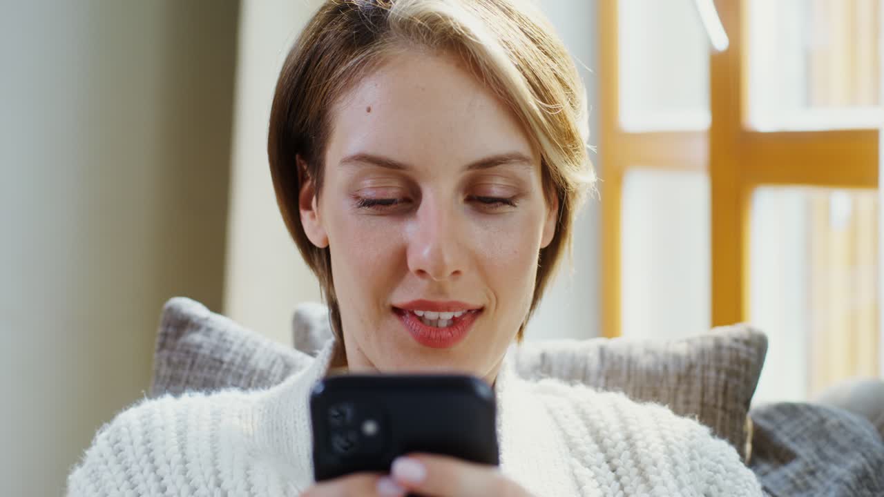 donna che usa uno smartphone a casa