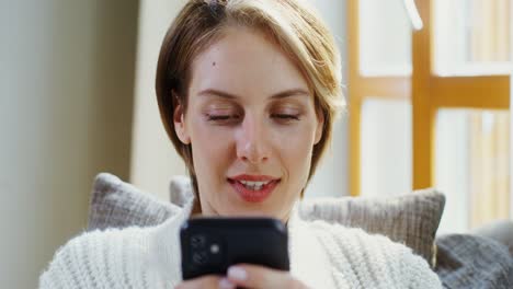 mujer usando un teléfono inteligente en casa