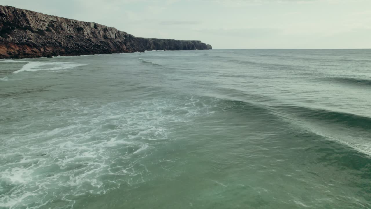 las olas del océano chocando contra una costa rocosa