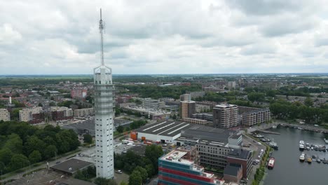 detailed drone view circling a modern telecom tower in alphen aan den rijn with surrounding buildings and marina