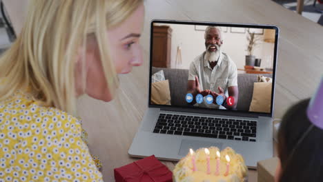 madre y hija caucásicas celebrando su cumpleaños en video llamada en computadora portátil en casa
