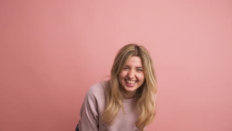 blonde caucasian young woman laughing energetically standing