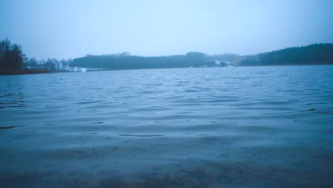 view of empy lake with small ripplets on a grey winter day