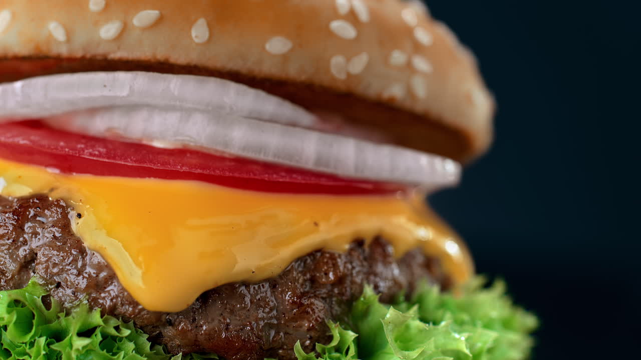 hamburguesa en pan de sésamo con carne de res, queso derretido y verduras en macro