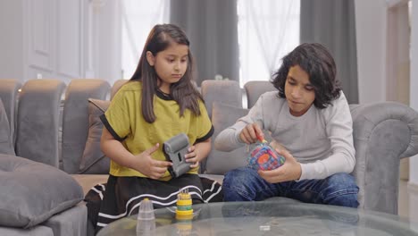 niños indios tratando de arreglar un coche eléctrico robótico