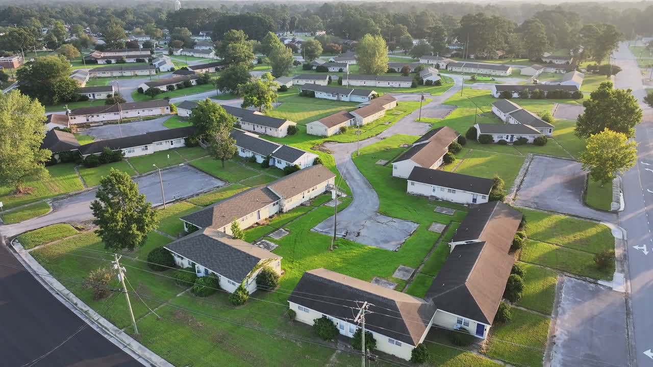 Cinematic drone shot of abandoned apartments with vegetation growing on the buildings, tilting down aerial footage