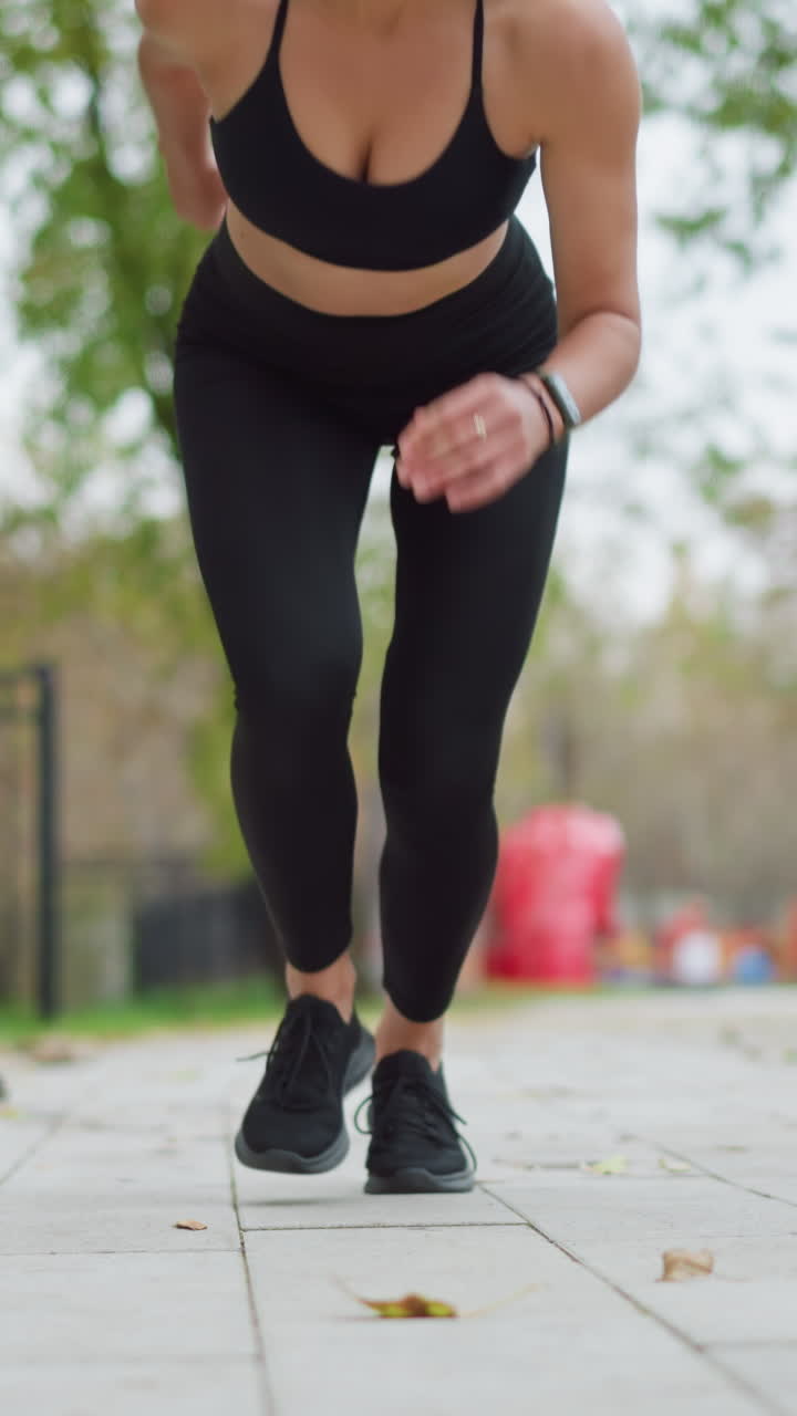 Athlete in starting position ready to run, crouched on the ground with focus, preparing to take off from a sprint position in a park. Athletic stance set for a powerful run in outdoor setting