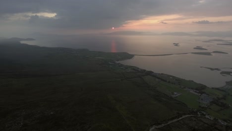 Toma-Aérea-Descendiendo-De-La-Montaña-Croagh-Patrick-En-Una-Noche-Nublada-Durante-La-Puesta-De-Sol