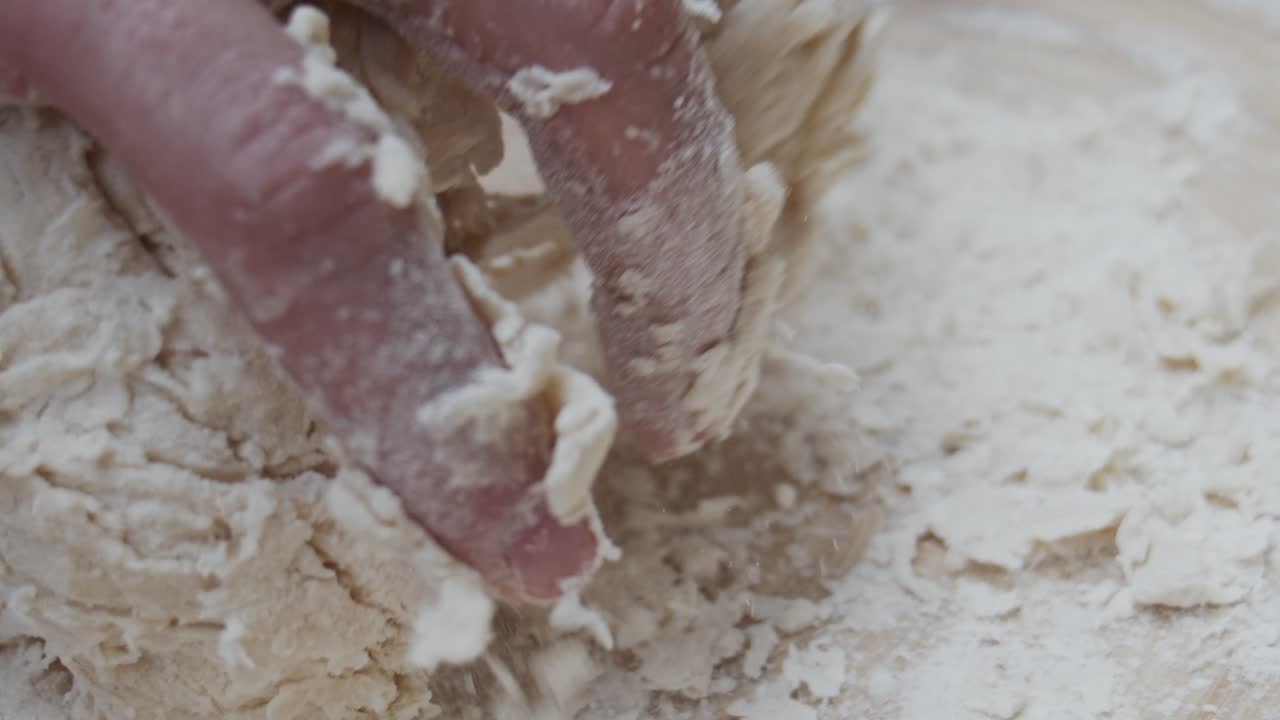 주방장은 피자 반죽을 나무 테이블에 있는 깊은 접시에 담습니다.