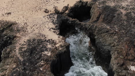 Fantastic-aerial-shot-approaching-one-of-the-Caletones-arches-located-on-the-island-of-La-Graciosa