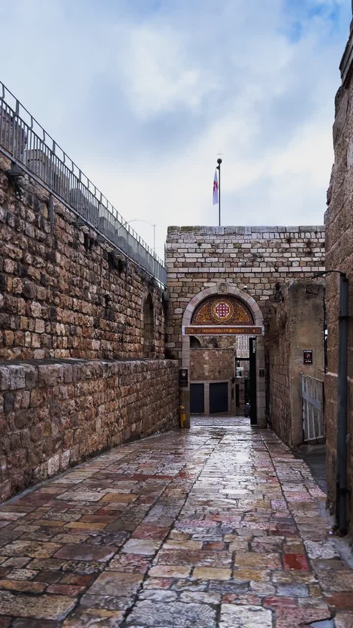 Vicolo di ciottoli bagnati che conduce a un cancello nella città vecchia di Gerusalemme