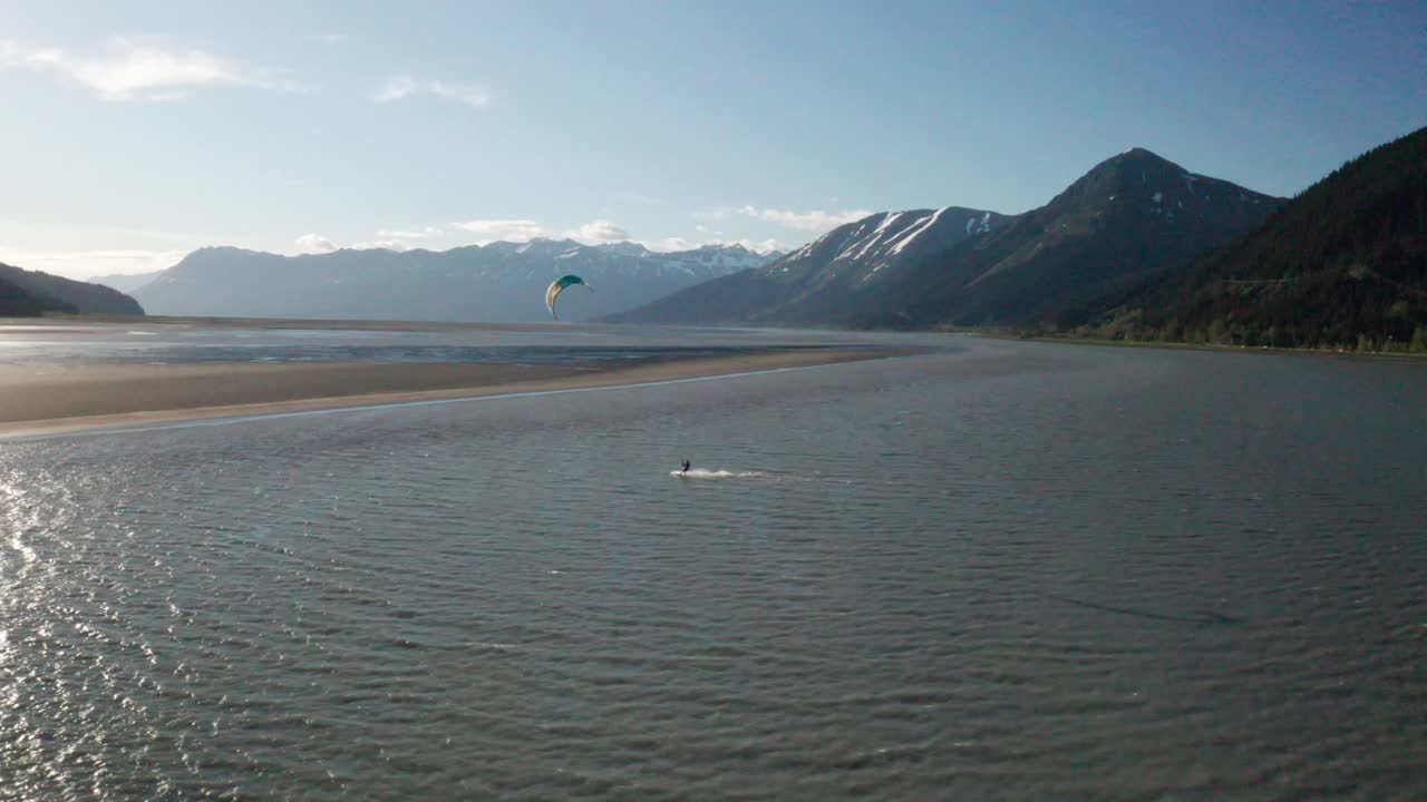 Drone footage of a water skier para-skiing with a parachute on a windy summer day in Turnagain Arm of the Cook Inlet in Alaska