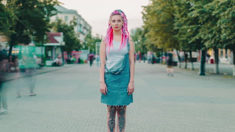 young woman with pink dreadlocks in denim overalls