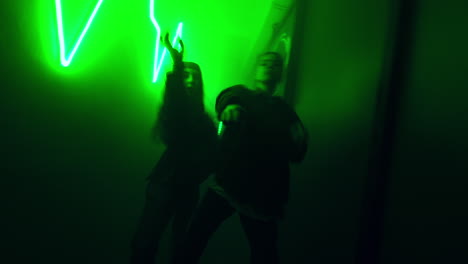 girls dancing hip hop. contemporary dance style performed by females in the corridor with green illumination.