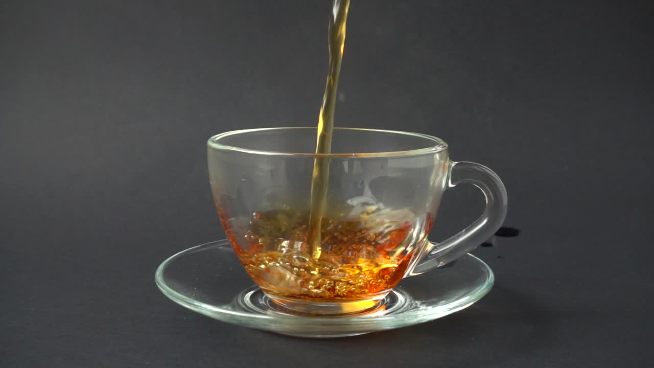 Il tè viene versato nella tazza. Movimento rallentato