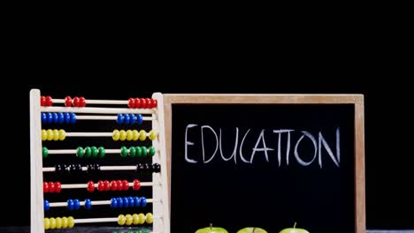 apple, abacus and slate on table