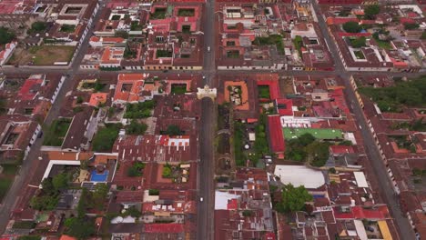 Rising-up-above-Santa-catalina-arch-at-Antigua-Guatemala,-aerial