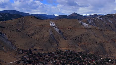 snowy lookout mountain indian peaks windy road genesse morrison golden evergreen aerial drone view colorado winter sunny morning afternoon buffalo bills grave blue sky clouds rocky mountains upwards