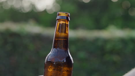 cámara lenta bajando la botella de cerveza abierta marrón