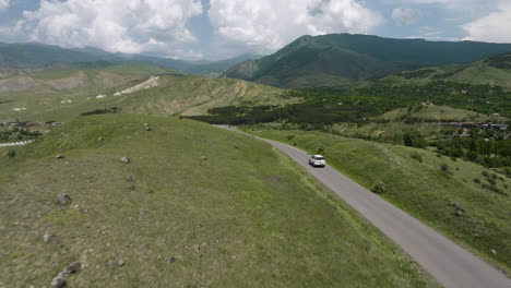 car driving through empty road with panoramic view of mountain range in summer at daytime in georgia