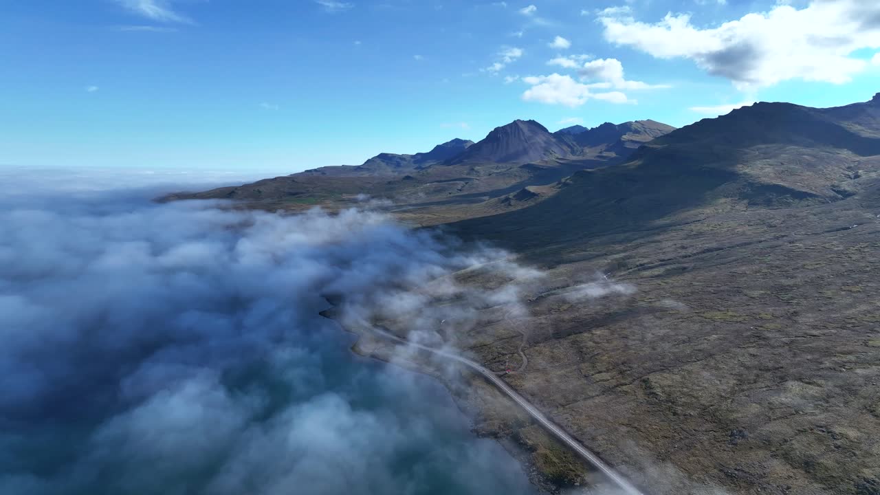 volando sobre las nubes en el hermoso fiordo oriental de faskrudsfjordur - carretera de circunvalación del este de islandia