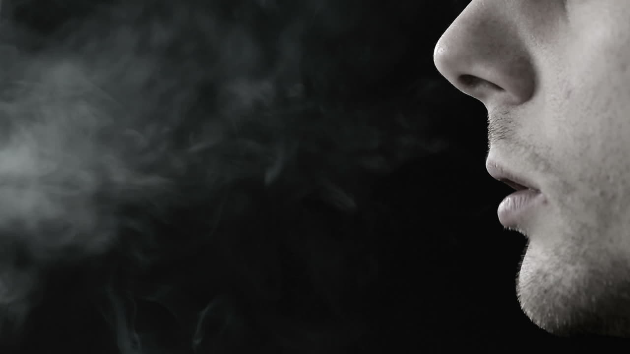 흑백으로 담배를 피우는 남자