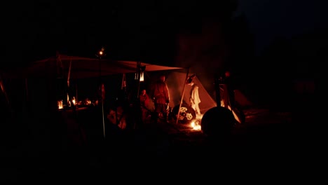 caballeros de la edad media descansando en una tienda de campaña por la noche con una fogata para calentarse