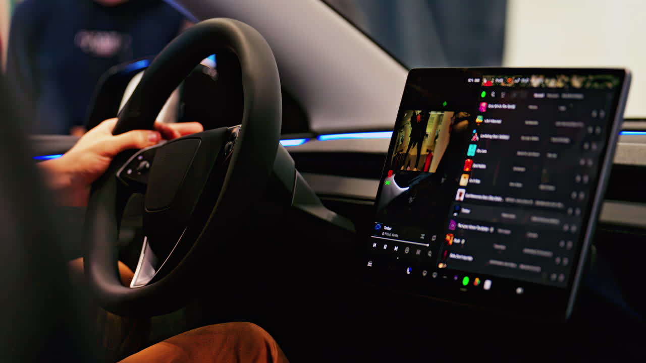 Close up of the steering wheel in the inside of a car with a big screen