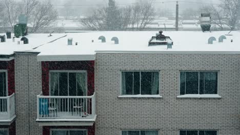 esterno di neve sulla costruzione di mattoni di appartamento vuoto urbano con finestre e balcone durante il giorno 4k