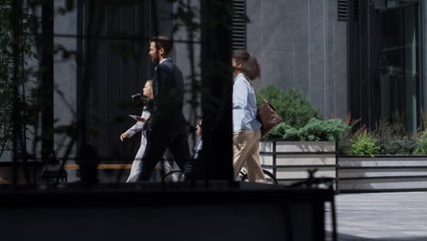 corporate people walking holding bicycle kickscooter downtown. green transport.