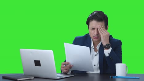 stressed and tensed indian manager reading and signing reports green screen