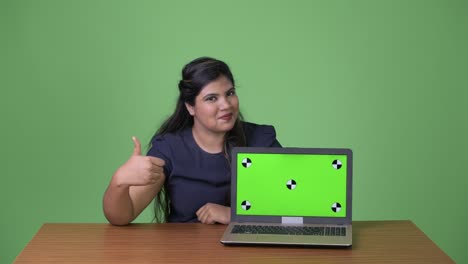 joven sobrepeso hermosa mujer de negocios india contra fondo verde