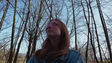 girl looking around in a forrest thinking about something