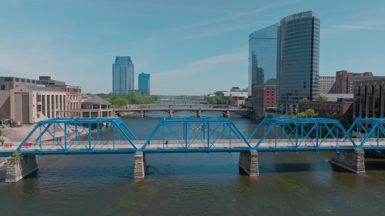 Blå bro over Grand River i sentrum av Grand Rapids, Michigan, med dronevideo som trekker seg tilbake