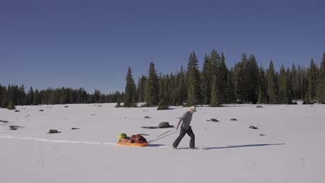 Mann-In-Der-Natur-Mit-Schneeschuhen-Und-Seinem-Schlitten,-Der-Die-Wildnis-Erkundet