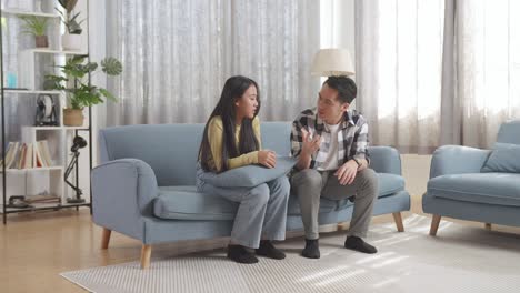 father and daughter talking on sofa