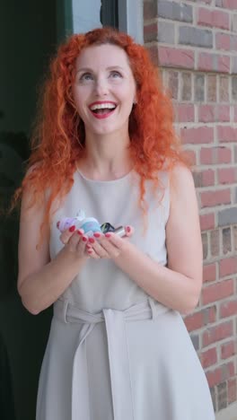a woman with red hair shares a joyful moment with her toys in this video a woman with red hair enjoys a moment with her stuffed animal and a unicorn toy by a charming brick building evoking joy and nostalgia