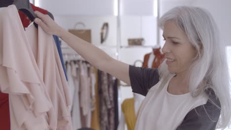 happy shop customer browsing clothes on rack