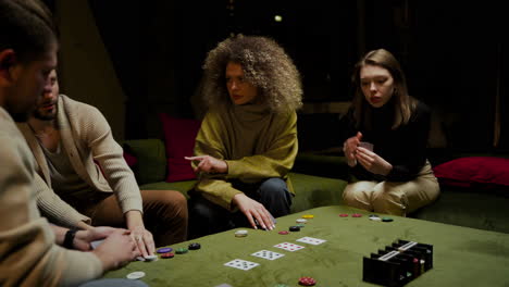 gruppe von freunden, die auf der couch im wohnzimmer poker spielen 3