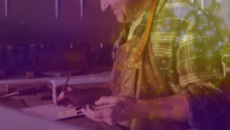 Animation-of-caucasian-male-worker-smiling-in-workshop-over-light-spots