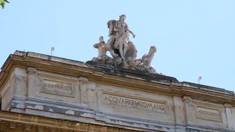 group of statues depicting the chariot of venus pulled by a triton and a nereid on top of the roman aquarium building in rome, italy