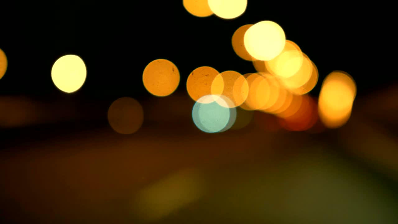 conducir un coche a través de la carretera de la noche, la autopista. luces desenfocadas calle de los ángeles resumen. ciudad fondo borroso. movimientos círculos bokeh de tráfico nocturno.