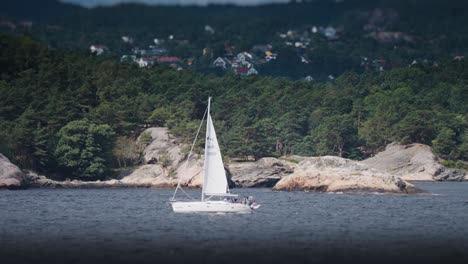 a small sailboat battling the waves between the rocky islands