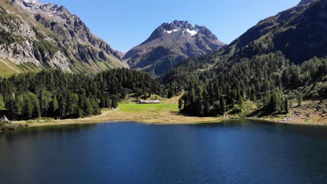 Aerial-flyover-over-Lagh-da-Cavloc-on-a-sunny-day-in-Maloja,-Switzerland-towards-the-peak-of-Monte-Forno