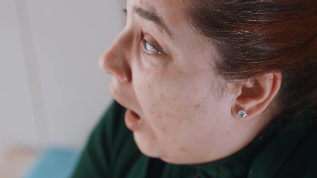 La donna mostra ansia. Mostra visibilmente nervosismo. Il suo viso rivela chiaramente il suo disagio. La sua espressione indica inequivocabilmente preoccupazione e apprensione nel suo sguardo