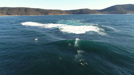 aerial slow motion shot of surfer carving into curling wave with glowing green face