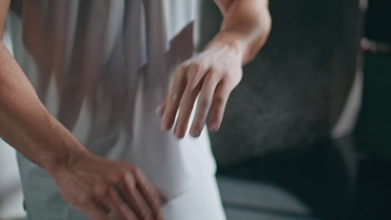 Closeup athlete clapping hands with talc powder. Man using magnesium in loft gym